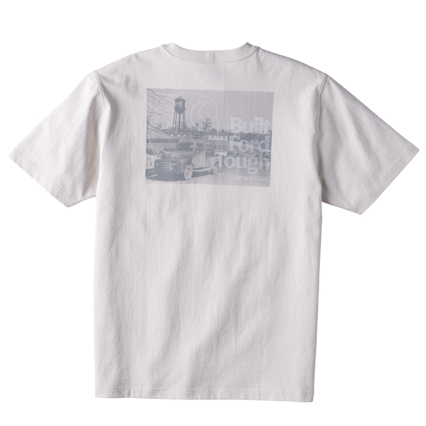 A white short-sleeve crewneck t-shirt shown from the back, featuring a large rectangular gray graphic print on the upper back with a vintage truck, a water tower, and faded text.